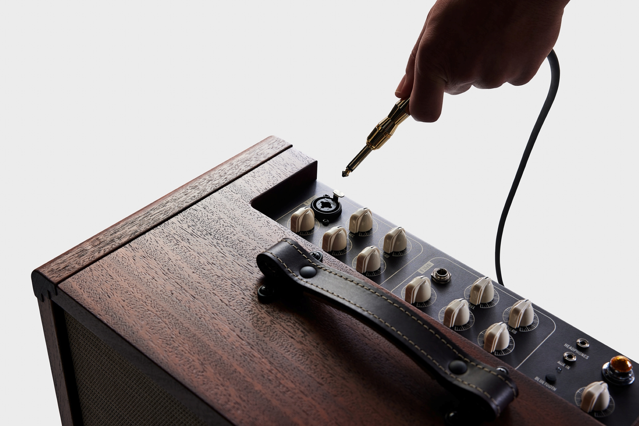 Image of Circa74 env 220427 av150 10 on white plugging guitar cable into amp